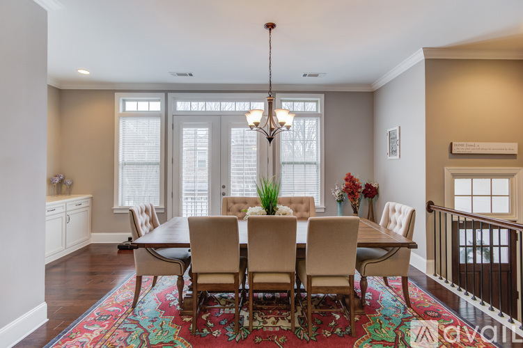 A dining room with a large table and chairs.