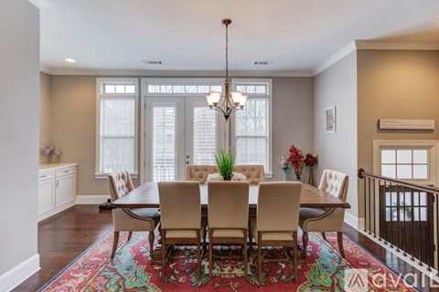 A dining room with a large table and chairs.