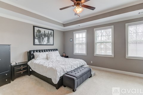 A bedroom with a large bed and a ceiling fan.