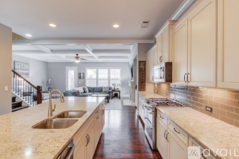 A kitchen with a marble countertop and wooden cabinets.