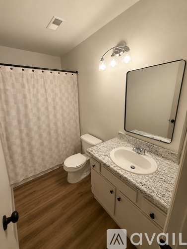 A bathroom with a toilet, sink, and shower.