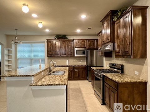 A kitchen with brown cabinets and a granite countertop.