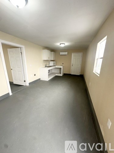 A spacious room with a grey floor and white walls.