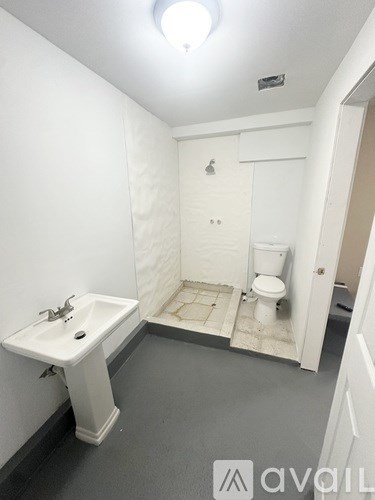 A bathroom with a toilet, sink and shower.