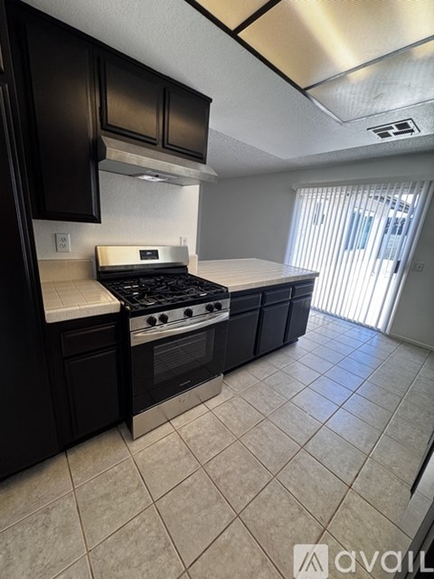 A kitchen with black cabinets and a white stove top oven.