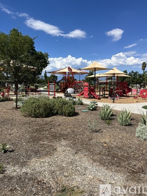A playground with a red slide and yellow umbrellas.