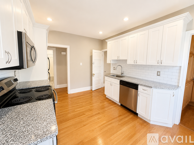 A kitchen with white cabinets and a granite countertop.