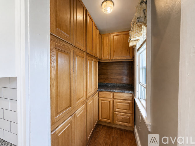 A kitchen with wooden cabinets and a window.