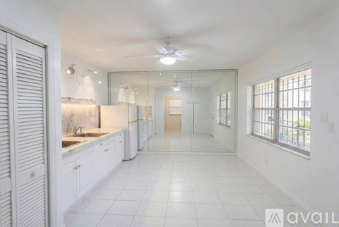 A spacious kitchen with white cabinets and a large island.