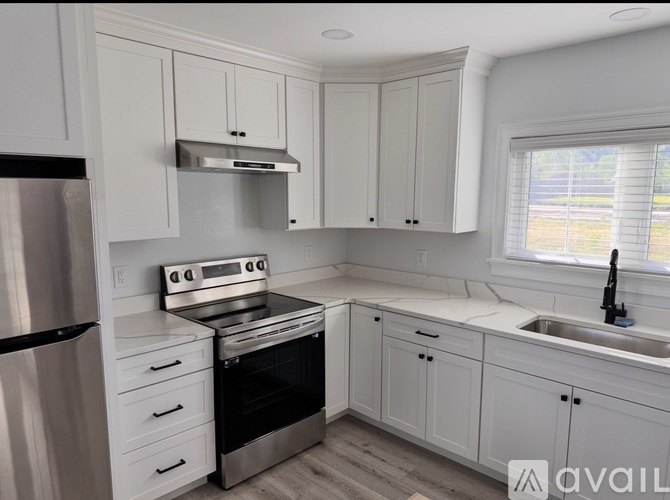 A kitchen with white cabinets and stainless steel appliances.