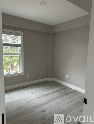 A room with a window and wooden flooring.