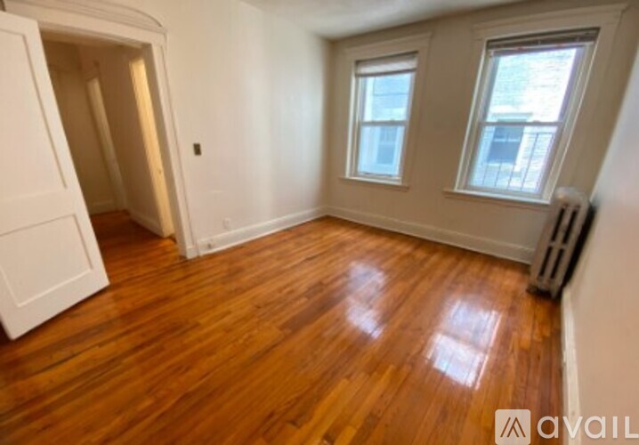 A room with wooden floors and two windows.