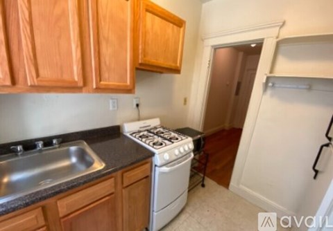 A kitchen with wooden cabinets and a white stove top oven.