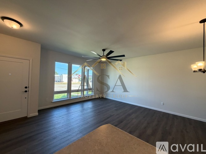A room with a ceiling fan and a large window with a view of the outside.