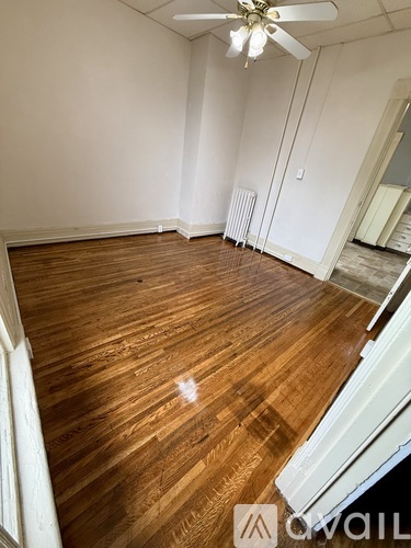 A room with wooden flooring and a ceiling fan.