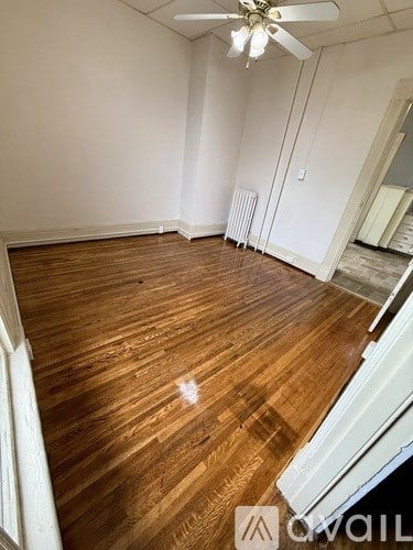 A room with wooden flooring and a ceiling fan.