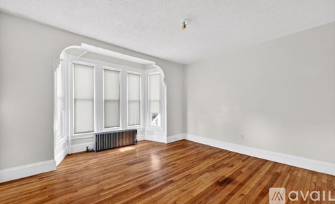 A room with a large window and wooden floors.