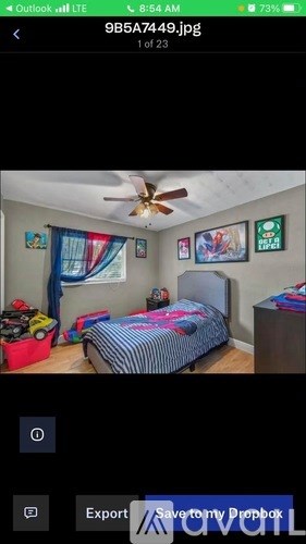 A bedroom with a bed, dresser, and ceiling fan.