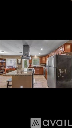 A kitchen with wooden cabinets and a black refrigerator.