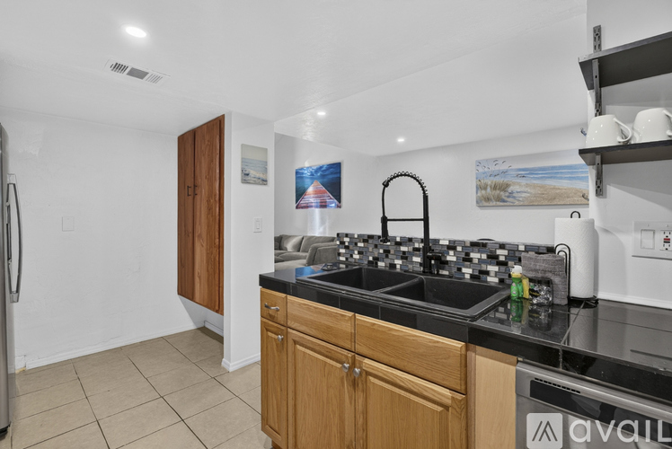 A kitchen with a black counter top and wooden cabinets.