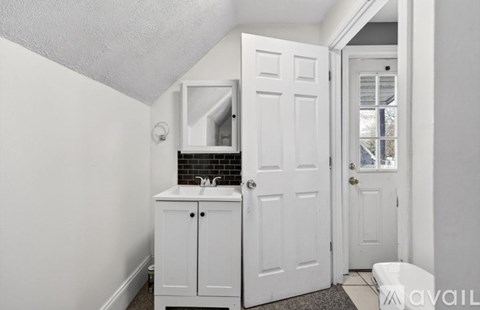 A white bathroom with a sink and a toilet.