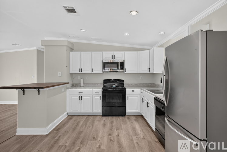 A modern kitchen with white cabinets and stainless steel appliances.
