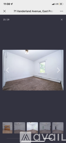 A room with a carpeted floor and a window.