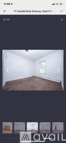 A room with a carpeted floor and a window.