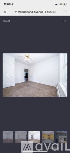 A room with a ceiling fan and carpeted floor.