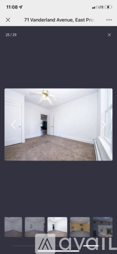 A room with a ceiling fan and carpeted floor.