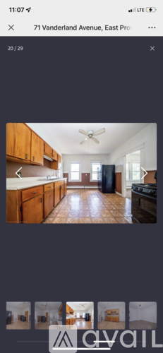 A kitchen with wooden cabinets and a tiled floor.