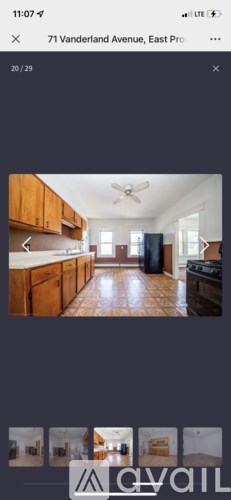 A kitchen with wooden cabinets and a tiled floor.