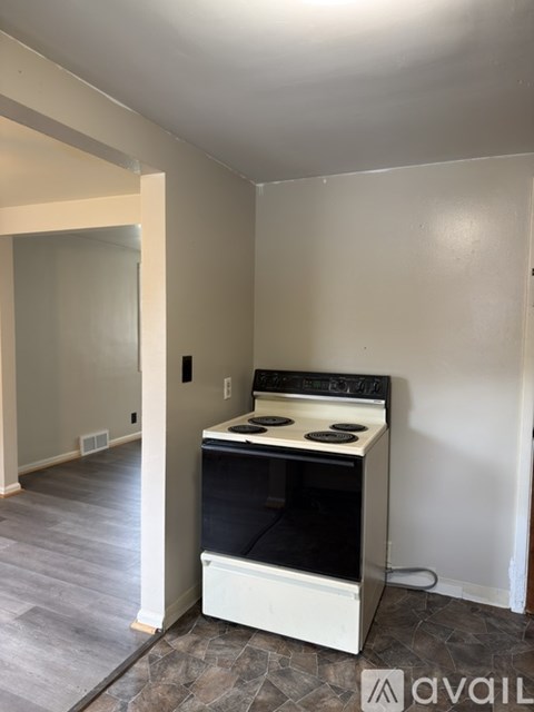 A white stove in a kitchen with a tile floor.