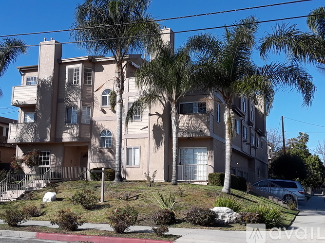 A large beige apartment building with a balcony on the second floor.