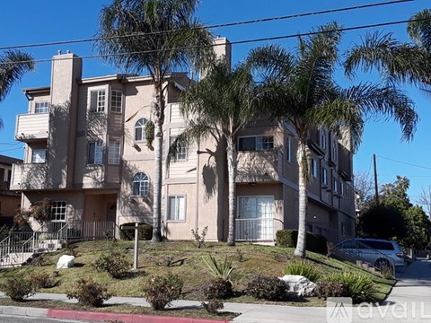 A large beige apartment building with a balcony on the second floor.