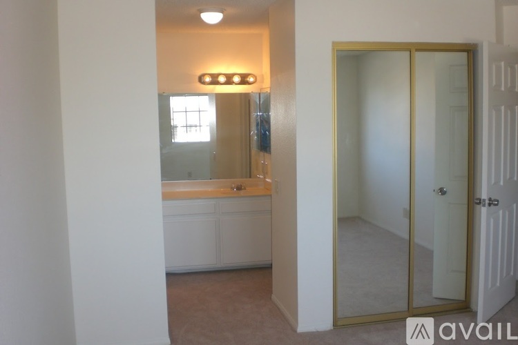 A bathroom with a glass door and a mirror above the sink.