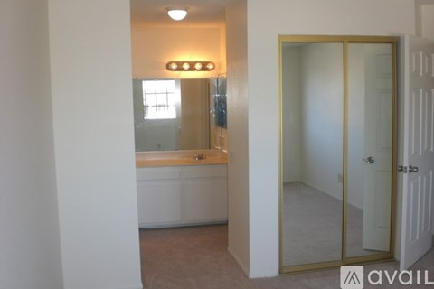 A bathroom with a glass door and a mirror above the sink.