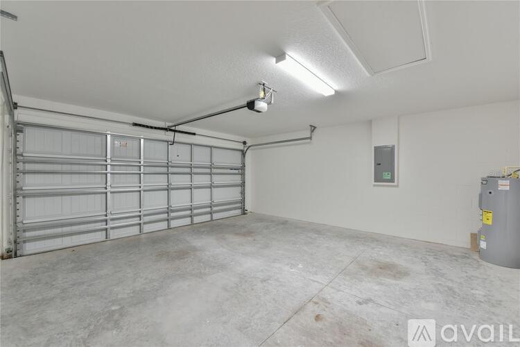 A spacious garage with a closed metal door and a concrete floor.