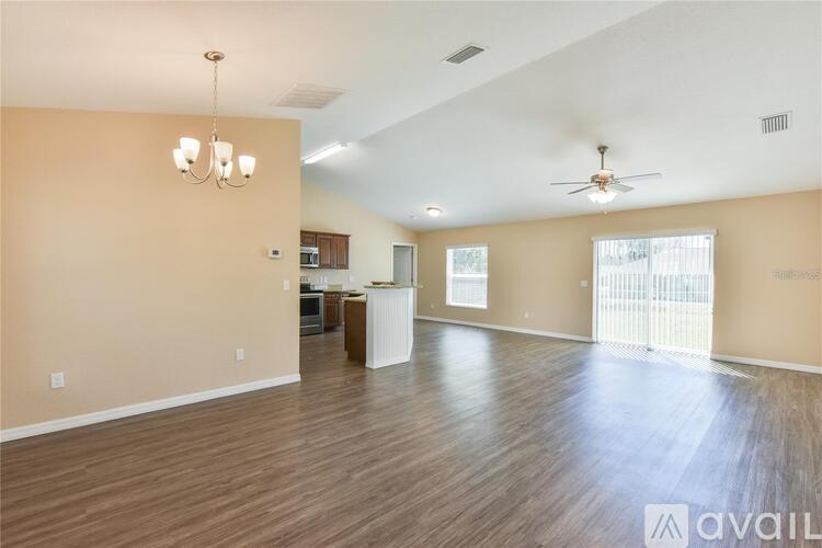 A spacious living room with wooden floors and a ceiling fan.