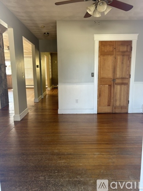 A room with a wooden floor and a ceiling fan.