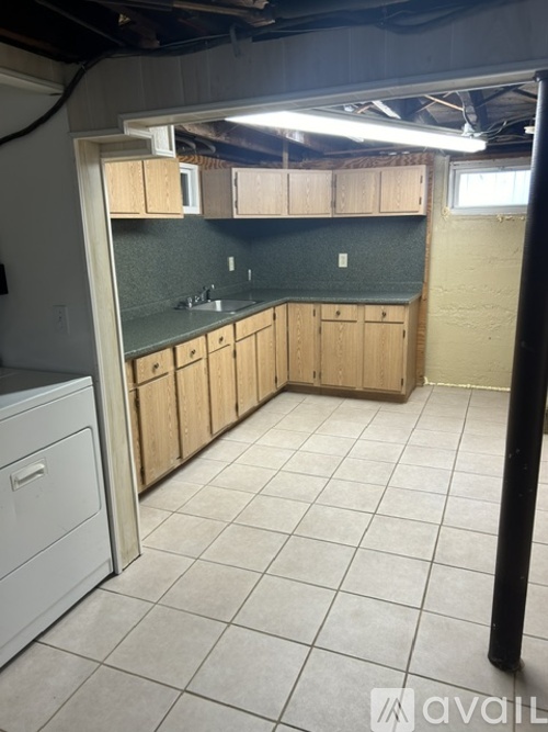 A kitchen area with wooden cabinets and a green backsplash.