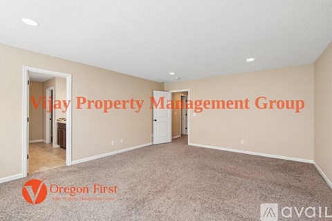 A spacious room with carpeted floor and white walls, with text overlays indicating it is managed by V????? Property Management Group and Oregon First.