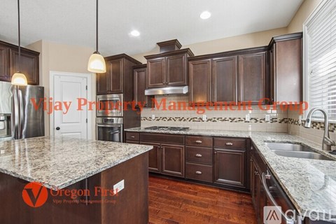 A kitchen with dark wood cabinets and a granite countertop.