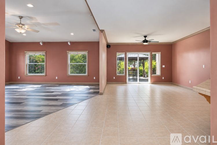 A spacious room with a ceiling fan and sliding glass doors.