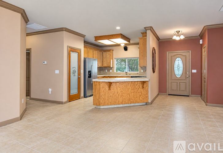 A kitchen with a wooden island and a refrigerator with a glass door.