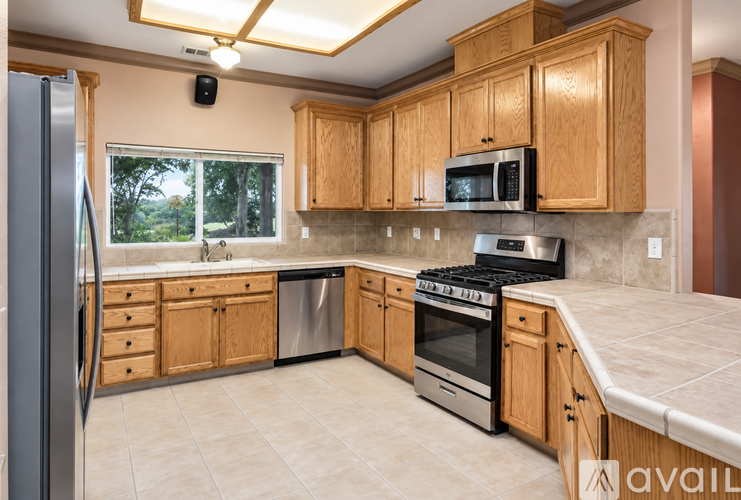 A kitchen with wooden cabinets and a stainless steel refrigerator.