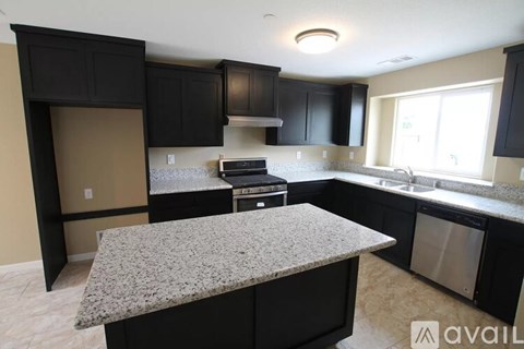 A kitchen with black cabinets and granite countertops.