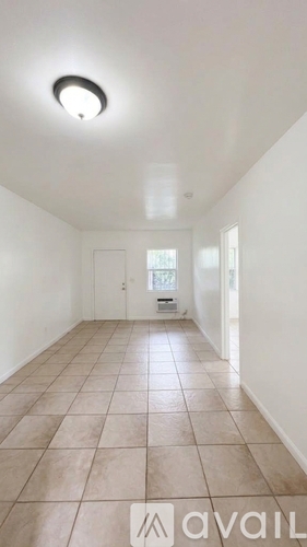 A room with tiled flooring and a single light fixture on the ceiling.