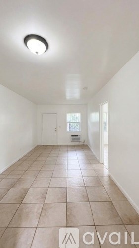 A room with tiled flooring and a single light fixture on the ceiling.