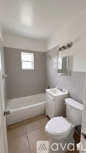A bathroom with a toilet, sink, and bathtub.